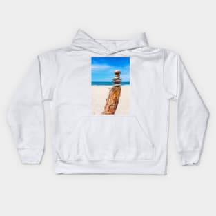 Stack of stones on the beach against blue sky Kids Hoodie